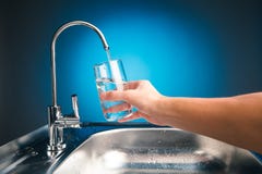 Remettez verser un verre de l'eau du robinet de filtration photos libres de droits Remettez verser un verre de l'eau du robinet de filtration photos libres de droits