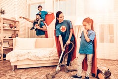 Rengörande hus för gullig Superherofamilj med ungar fotografering för bildbyråer Rengörande hus för gullig Superherofamilj med ungar fotografering för bildbyråer