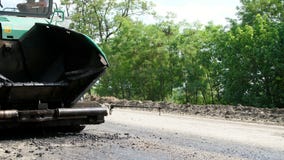 Repair of a highway, on the road there is a special technique for laying a new fresh asphalt pavement, covering . Road stock video Repair of a highway, on the road there is a special technique for laying a new fresh asphalt pavement, covering . Road stock video