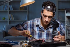 Repairmanen som försöker att reparera bärbara datorn med miscroscope Royaltyfri Bild Repairmanen som försöker att reparera bärbara datorn med miscroscope Royaltyfri Bild