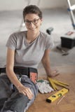 Repairwoman se reposant sur le plancher et la pose image stock Repairwoman se reposant sur le plancher et la pose image stock
