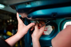 Reparação do close up de um carro azul quebrado na garagem pelas mãos de machanic fotografia de stock Reparação do close up de um carro azul quebrado na garagem pelas mãos de machanic fotografia de stock