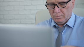 Responsabile con gli occhiali che lavorano al computer portatile immagini stock Responsabile con gli occhiali che lavorano al computer portatile immagini stock