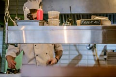 restaurant kitchen close up with Reserved table and blurred chief cook on the background. stock image restaurant kitchen close up with Reserved table and blurred chief cook on the background. stock image