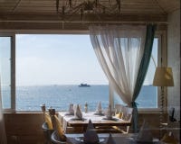 Restaurante com vista impressionante da janela aberta no mar fotografia de stock Restaurante com vista impressionante da janela aberta no mar fotografia de stock