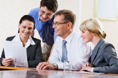 Results of work. Team of four successful professional gathered together at the table speaking about their results of work Results of work. Team of four successful professional gathered together at the table speaking about their results of work
