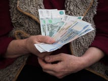 Retired with Russian rubles in his hands. The concept of social security. stock photos Retired with Russian rubles in his hands. The concept of social security. stock photos