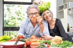 Retired senior couple having fun in kitchen with healthy food