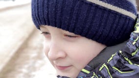 Retrato ascendente próximo de um menino preteen bonito com os olhos surpreendentes que sentam-se em um banco no parque no inverno vídeos de arquivo Retrato ascendente próximo de um menino preteen bonito com os olhos surpreendentes que sentam-se em um banco no parque no inverno vídeos de arquivo