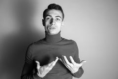 Retrato blanco y negro de un hombre de mente abierta joven en un puente del cuello alto, teniendo una conversación, expalining fotografía de archivo Retrato blanco y negro de un hombre de mente abierta joven en un puente del cuello alto, teniendo una conversación, expalining fotografía de archivo