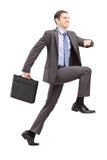 Retrato completo do comprimento de um homem de negócios que executa uma etapa enorme para imagem de stock Retrato completo do comprimento de um homem de negócios que executa uma etapa enorme para imagem de stock