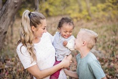 Retrato cândido bonito de uma mãe que joga com seus filhos bi-raciais bonitos foto de stock Retrato cândido bonito de uma mãe que joga com seus filhos bi-raciais bonitos foto de stock