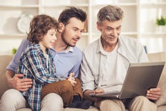 Retrato da geração Avô, pai e filho sentando e usando o portátil no sofá fotografia de stock Retrato da geração Avô, pai e filho sentando e usando o portátil no sofá fotografia de stock