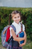 Retrato da menina da escola com a trouxa após a escola Começo das lições Primeiro dia da queda fotografia de stock royalty free Retrato da menina da escola com a trouxa após a escola Começo das lições Primeiro dia da queda fotografia de stock royalty free