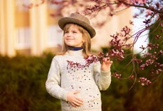 Retrato da mola, menina ador?vel na caminhada do chap?u no jardim da ?rvore da flor no por do sol imagem de stock Retrato da mola, menina ador?vel na caminhada do chap?u no jardim da ?rvore da flor no por do sol imagem de stock