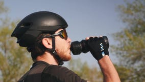 Retrato da água potável profissional nova do ciclista antes de sua sessão de formação Conceito do ciclismo video estoque Retrato da água potável profissional nova do ciclista antes de sua sessão de formação Conceito do ciclismo video estoque