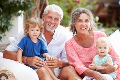 Retrato das avós que sentam-se fora com netos fotografia de stock Retrato das avós que sentam-se fora com netos fotografia de stock