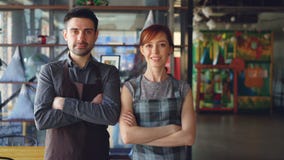 Retrato de dos pequeños propietarios de negocio orgullosos que colocan el nuevo café espacioso interior y la sonrisa Arranque de Retrato de dos pequeños propietarios de negocio orgullosos que colocan el nuevo café espacioso interior y la sonrisa Arranque de