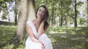 Retrato de la chica joven linda con el pelo moreno largo que lleva un vestido blanco largo de la moda del verano que asiste debaj metrajes Retrato de la chica joven linda con el pelo moreno largo que lleva un vestido blanco largo de la moda del verano que asiste debaj metrajes