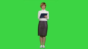 Retrato de la empresaria joven con la tableta que hace las preguntas sobre una pantalla verde, llave de la croma almacen de video Retrato de la empresaria joven con la tableta que hace las preguntas sobre una pantalla verde, llave de la croma almacen de video