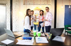 Retrato de la gente joven feliz en una reunión que mira la cámara y la sonrisa Diseñadores jovenes que trabajan junto en a imagen de archivo Retrato de la gente joven feliz en una reunión que mira la cámara y la sonrisa Diseñadores jovenes que trabajan junto en a imagen de archivo