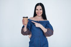Retrato de la muchacha morena alegre linda agradable elegante preciosa bonita atractiva en vestido de los vaqueros, señalando en imágenes de archivo libres de regalías Retrato de la muchacha morena alegre linda agradable elegante preciosa bonita atractiva en vestido de los vaqueros, señalando en imágenes de archivo libres de regalías
