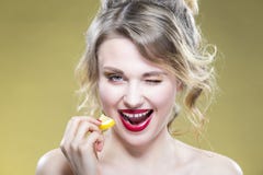 Retrato de la muchacha rubia caucásica atractiva que come el pedazo minúsculo del limón