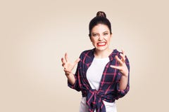 Retrato de la mujer caucásica diseñada casual joven subrayada y enfadada con el bollo del pelo que lleva a cabo las manos en gest foto de archivo libre de regalías Retrato de la mujer caucásica diseñada casual joven subrayada y enfadada con el bollo del pelo que lleva a cabo las manos en gest foto de archivo libre de regalías