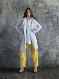 Retrato de la mujer joven elegante en la camisa blanca, pantalones amarillos y capa fotografía de archivo Retrato de la mujer joven elegante en la camisa blanca, pantalones amarillos y capa fotografía de archivo
