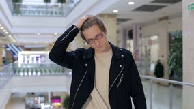 Retrato de um homem novo moderno nos vidros em um grande shopping Compras video estoque Retrato de um homem novo moderno nos vidros em um grande shopping Compras video estoque
