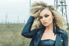 Retrato de um louro bonito em um casaco de cabedal com uma composição e um penteado foto de stock Retrato de um louro bonito em um casaco de cabedal com uma composição e um penteado foto de stock