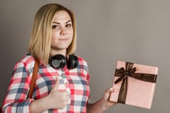 Retrato de uma jovem mulher que guarda um presente Estudante em s quadriculado foto de stock Retrato de uma jovem mulher que guarda um presente Estudante em s quadriculado foto de stock