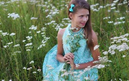 Retrato de uma menina bonita em um vestido azul e nos ornamento que levantam fora imagem de stock Retrato de uma menina bonita em um vestido azul e nos ornamento que levantam fora imagem de stock