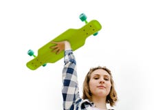 Retrato de uma moça em uma camisa de manta que guarde um longboard em uma mão imagens de stock Retrato de uma moça em uma camisa de manta que guarde um longboard em uma mão imagens de stock