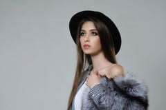Retrato de uma mulher em um chapéu negro e em uma pele, que realize em h imagens de stock Retrato de uma mulher em um chapéu negro e em uma pele, que realize em h imagens de stock
