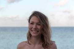 Retrato de uma mulher feliz nova no feriado Mar como o fundo fotografia de stock Retrato de uma mulher feliz nova no feriado Mar como o fundo fotografia de stock