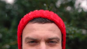 Retrato de un hombre en un casquillo rojo en tiempo nevoso al aire libre almacen de video Retrato de un hombre en un casquillo rojo en tiempo nevoso al aire libre almacen de video