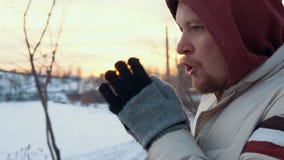 Retrato de un hombre joven que se coloca congelado contra un paisaje urbano en invierno almacen de metraje de vídeo Retrato de un hombre joven que se coloca congelado contra un paisaje urbano en invierno almacen de metraje de vídeo