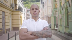 Retrato de un hombre de Oriente Medio calvo acertado confiado que lleva una camiseta blanca que mira la cámara C?mara lenta almacen de metraje de vídeo Retrato de un hombre de Oriente Medio calvo acertado confiado que lleva una camiseta blanca que mira la cámara C?mara lenta almacen de metraje de vídeo