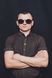 Retrato de un hombre vestido en una camisa negra y gafas de sol marrones imagen de archivo Retrato de un hombre vestido en una camisa negra y gafas de sol marrones imagen de archivo