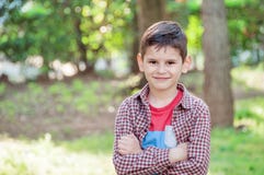 Retrato de un muchacho hermoso en el parque, colocándose con las CRO (coordinadora) de los brazos fotos de archivo libres de regalías Retrato de un muchacho hermoso en el parque, colocándose con las CRO (coordinadora) de los brazos fotos de archivo libres de regalías