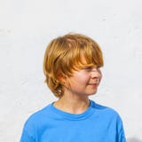 Retrato de un muchacho sonriente con el pelo rubio largo imagen de archivo libre de regalías Retrato de un muchacho sonriente con el pelo rubio largo imagen de archivo libre de regalías