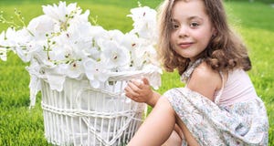Retrato de un niño lindo que sostiene una cesta de mimbre con el flujo blanco imágenes de archivo libres de regalías Retrato de un niño lindo que sostiene una cesta de mimbre con el flujo blanco imágenes de archivo libres de regalías