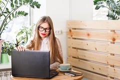 Retrato de una empresaria casual feliz en el suéter que se sienta en su lugar de trabajo en oficina foto de archivo Retrato de una empresaria casual feliz en el suéter que se sienta en su lugar de trabajo en oficina foto de archivo