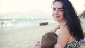 Retrato de una madre encantadora con un bebé en sus brazos La mamá con el bebé está gozando del aire fresco, mamá es amamantamien Retrato de una madre encantadora con un bebé en sus brazos La mamá con el bebé está gozando del aire fresco, mamá es amamantamien