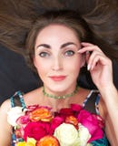 Retrato de una mujer hermosa joven, morenita con un ramo de rosas Ella miente en el piso y lleva a cabo su mano al lado de la car fotos de archivo libres de regalías Retrato de una mujer hermosa joven, morenita con un ramo de rosas Ella miente en el piso y lleva a cabo su mano al lado de la car fotos de archivo libres de regalías