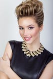retrato de una mujer joven atractiva feliz hermosa que sonríe en un vestido de noche negro con el pelo y maquillaje con joyería c Foto de archivo libre de regalías retrato de una mujer joven atractiva feliz hermosa que sonríe en un vestido de noche negro con el pelo y maquillaje con joyería c Foto de archivo libre de regalías