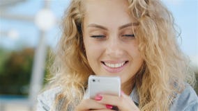Retrato de una mujer joven atractiva que mira la pantalla del teléfono: sonrisa almacen de metraje de vídeo Retrato de una mujer joven atractiva que mira la pantalla del teléfono: sonrisa almacen de metraje de vídeo