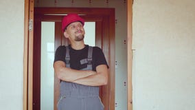 Retrato del constructor adulto joven hermoso barbudo alegre en fondo de un apartamento renovado metrajes Retrato del constructor adulto joven hermoso barbudo alegre en fondo de un apartamento renovado metrajes