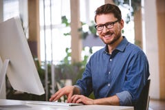 Retrato del hombre de negocios feliz que trabaja en el ordenador en la oficina creativa imagen de archivo libre de regalías Retrato del hombre de negocios feliz que trabaja en el ordenador en la oficina creativa imagen de archivo libre de regalías